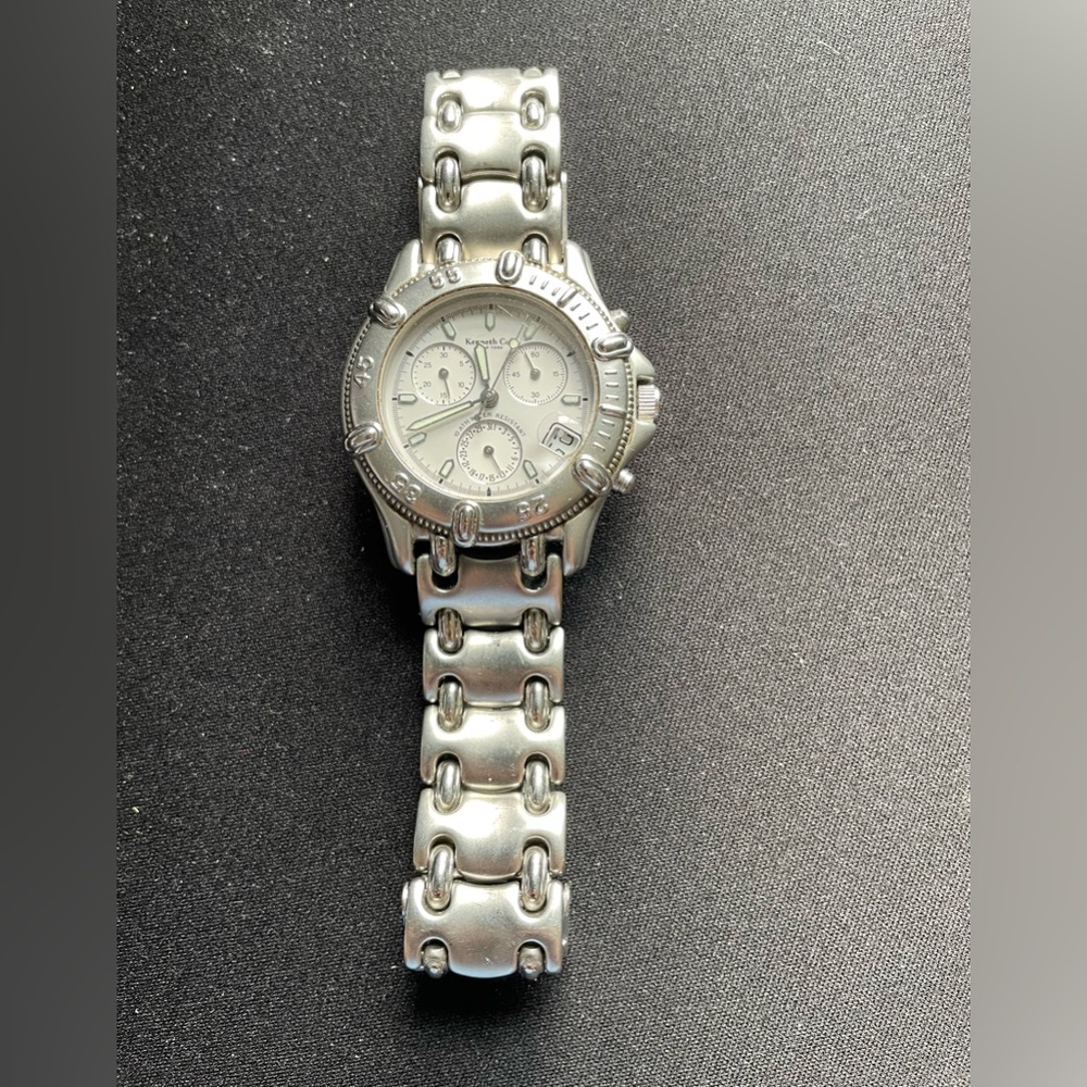 Kenneth Cole Silver Watch with white face and a clasp closure (needs a battery)
